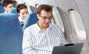 Un homme utilise son ordinateur en avion (illustration).