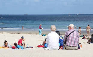 Un couple de retraités assis au bord de la plage à Dinard.