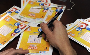 Un joueur cochant une grille du Loto.