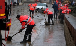 Des équipes nettoient les rues de Trèbes, inondées, le 16 octobre 2018.