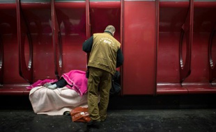 Un travailleur social de la RATP parle à un SDF dans une station de métro à Paris, le 27 mars 2013