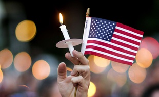 Une bougie et un drapeau américain lors d'un hommage aux victimes d'Orlando, à Atlanta, le 12 juin 2016.