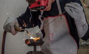 Un jeune apprenti soude un tuyau durant un atelier plomberie à l'Université régionale des métiers de l'artisanat le 26 septembre 2014 à Arras