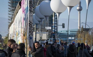 Des personnes regardent une oeuvre lumineuse installée le long de l'ancien Mur de Berlin, le 8 novembre 2014