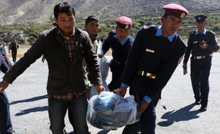 Des policiers népalais transportent les corps de randonneurs tués dans une avalanche à Jomsom le 17 octobre 2014