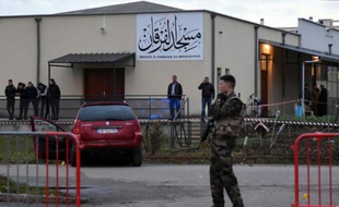 Des policiers près d'une voiture endommagée devant la mosquée de Valence, le 1er janvier 2016, après qu'un homme a foncé en voiture sur un militaire
