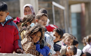 Sidon (Liban), le 22 mars 2015. Des enfants syriens attendant dans un camp de réfugiés au Liban.