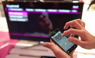 Un utilisateur de smartphone devant sa télé.