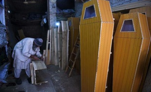 Un menuisier fabrique des cercueils le 6 janvier 2015 dans un atelier à Peshawar, dans le nord-ouest du Pakistan
