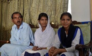 Ashiq Masih, le mari d'Asia Bibi, et leurs deux filles Esha (c) et Esham (d) à leur domicile à Lahore, le 31 octobre 2014