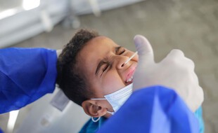 Illustration d'un enfant se faisant tester avec un prélèvement nasopharyngé.