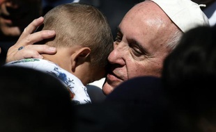 Le pape François étreint un enfant dans le camp de migrants de Moria sur l'île de Lesbos le 16 avril 2016