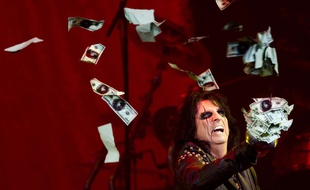 Le chanteur Alice Cooper jette en l'air des faux billets de 100 dollars lors d'un show dans le Michigan, le 2 juillet 2014.