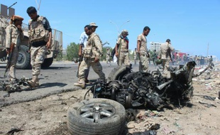 Les forces de sécurité yéménites inspectent le lieu de l'explosion d'une voiture piégée à Aden le 1er mai 2016