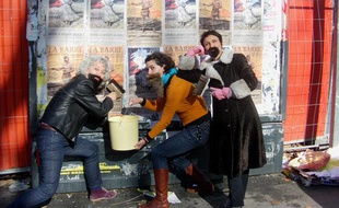 Des membres du collectif féministe La Barbe collent des affiches sur des espaces autorisés à Toulouse, le 6 mars 2012.