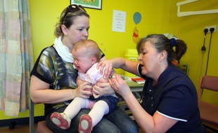 Une petite fille de 14 mois reçoit le vaccin contre la rougeole, les oreilles et la rubéole (ROR).