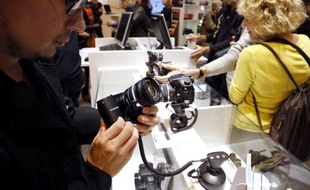 Un visiteur du Salon de la photo à Paris manipule un appareil, le 8 novembre 2012
