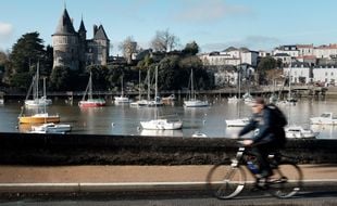 Un cycliste sur une roule longeant le port de Pornic.