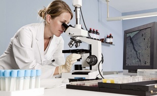 Une femme dans laboratoire utilise un microscope