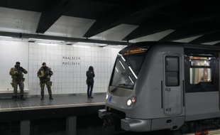 Des militaires belges montent la garde, le 25 avril 2016 à la station de métro Maelbeek à Bruxelles, à sa réouverture un mois et trois jours après les attentats jihadistes qui ont frappé la capitale belge, faisant 32 morts et des centaines de blessés