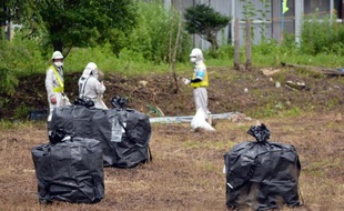 Des employés participent à une opération de décontamination le 17 juillet 2015 dans le village de Iitate dans la préfecture de Fukushima, qui n'a pas été évacué au moins un mois après l'accident de la centrale