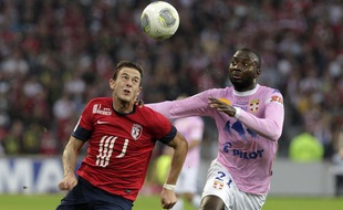 Lille, le 24 septembre 2013. Match comptant pour la 7eme journee du championnat de ligue 1 de football qui opposait le Lille OSC (LOSC) a Evian Thonon Gaillard au Stade Pierre Mauroy. Ici, le Lillois Nolan Roux a la lutte avec Cedric Mongongu d'Evian.