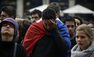 Un homme drapé dans l'emblème de la France dans un rassemblement en hommage aux victimes des attentats à Toulouse le 14 novembre 2015