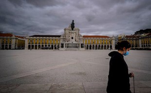 Une passante traverse la Praça do Comércio à Lisbonne.
