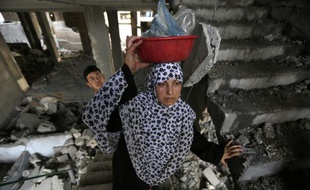 Une femme palestinienne se rend dans sa maison détruite après une frappe israélienne, le 13 juillet 2014 à Gaza
