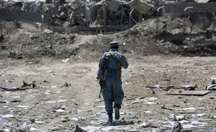 Un membre de la police afghane inspecte le site d'un attentat suicide près de Kaboul, en août 2016.