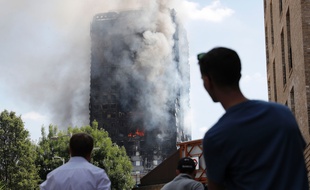 Des passants constatent l'état de la Grenfell Tower après l'incendie qui l'a ravagée dans la nuit de mardi à mercredi.