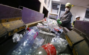 Un salarié trie les déchets plastiques à Sevran le 27 août 2015