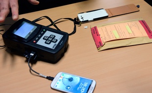 Un gendarme spécialisé dans les nouvelles technologies explorent les données d'un téléphone, le 9 janvier 2014.