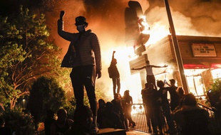 A Minneapolis, des manifestants devant un restaurant en feu, le 29 mai 2020.