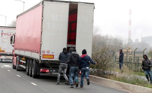 Des migrants tentent de monter dans un camion en partance pour la Grande Bretagne.