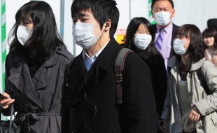 Des Japonais portent des masques dans la rue, en mars 2014 à Tokyo