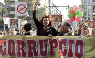 Photo d'archives d'une manifestante à Valence en Espagne le 13 avril 2013, portant une banderole qui dénonce la "corruption" politique dans le pays