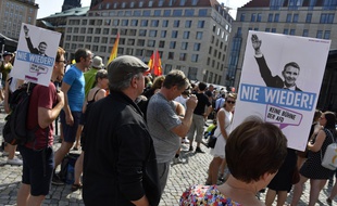 Des manifestants rassemblés contre l'extrême droite à Dresde en Allemagne. Sur la pancarte montrant le leader Bjoern Hoecke faisant un salut nazi, il est écrit +plus jamais+.