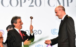 Manuel Pulgar (g), ministre de l'Environnement du Pérou, reçoit le marteau de la présidence de la 20e Conférence des parties (COP) des mains de son prédécesseur, Marcin Korolek, le 1er décembre 2014 à Lima