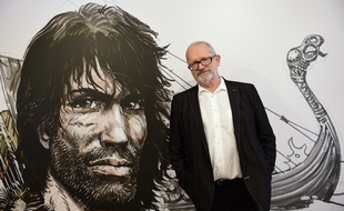 Le dessinateur Grzegorz Rosinski pose à côté devant un dessin représentant Thorgal,le héros qu'il a créé, à l'occasion de l'exposition «L'Univers de Thorgal» au musée de la BD de Bruxelles, le 24 mars 2015.