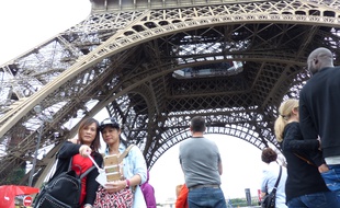 Deux touristes asiatiques immortalisent leur passage sous la tour Eiffel le 12 juillet 2016.