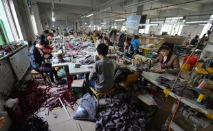 Des ouvrières fabriquent des sacs à main dans une usine à Baigou, dnas la province de Hebei, le 24 avril 2014