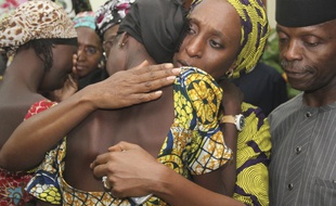 L'épouse du vice-président nigérian réconforte les lycéennes libérées par Boko Haram, à Abuja le 13 octobre 2016.
