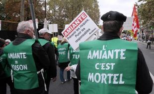 Des participants protestent contre l'amiante lors d'une manifestation, le 12 octobre 2013 à Paris, à l'appel de l'Association nationale de défense des victimes de l'amiante (Andeva)