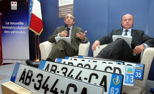 Yves Nossé, directeur du système d'immatriculation des véhicules et Gérard Gachet, porte-parole de la ministre de l'Intérieur, présentent les nouvelles plaques d'immatriculation qui entrent en vigueur le 15 avril 2009.