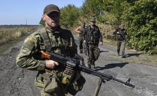 Des rebelles prorusses patrouillent sur une route près de la ligne de front avec l'armée ukrainienne, à Olenivka, le 14 septembre 2014