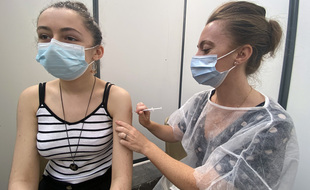 Lylie, 15 ans, en train de recevoir sa première injection de Pfizer par Caroline, l'infirmière volontaire