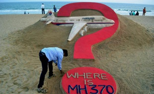 "Où est le MH370?", oeuvre de l'artiste indien Sudarsan Pattnaik (à gauche, au premier plan), sur une plage de Puri, en Inde, le 7 mars 2015