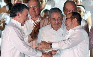 Le président colombien Juan Manuel Santos (à g.) et le chef des Farc Timochenko (à dr.) après la signature de l'accord, en présence du président cubain Raul Castro, à Carthagène, le 26 septembre 2016.