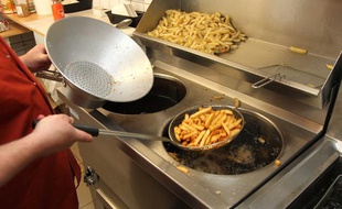 Des frites prêtes à sortir de l'huile bouillante (illustration).